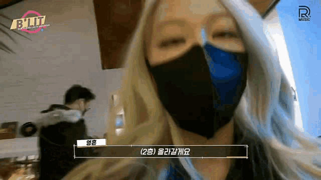 a woman wearing a mask with a r music logo on the bottom of her face