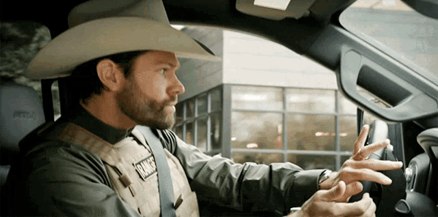 a man wearing a cowboy hat and a vest that says ranger on it