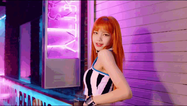 a woman with red hair is standing in front of a purple wall and a neon sign .