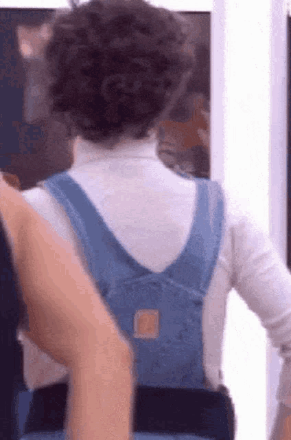 a person wearing a white turtleneck and a blue backpack .