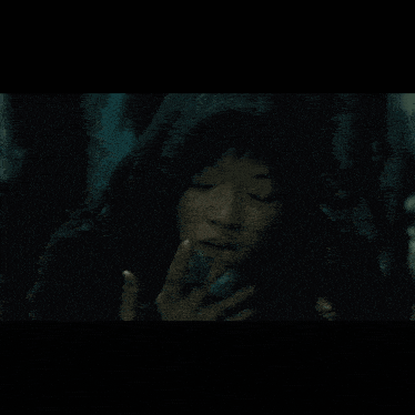 a young girl in a hooded jacket is reaching out her hand