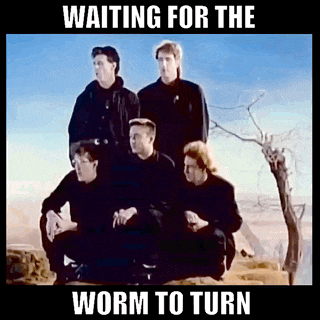 a group of men sitting on top of a hill with the words waiting for the worm to turn above them