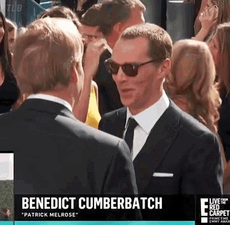 benedict cumberbatch is wearing sunglasses while talking to another man