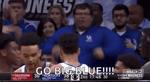 a basketball game is being played in front of a crowd of people and a referee .