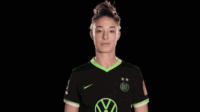 a woman wearing a black shirt with a green vw logo