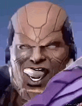 a close up of a man 's face with his tongue out and a helmet on .