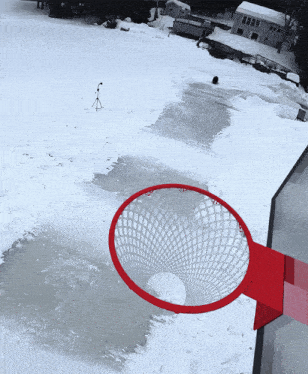 a red basketball hoop in a snowy area