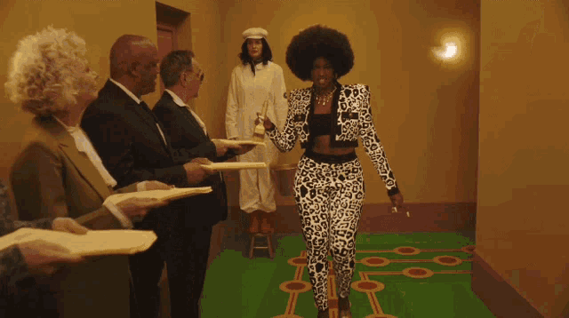 a woman in a leopard print suit is walking down a hallway surrounded by people