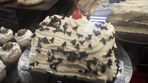 a cake with a cherry on top is on display