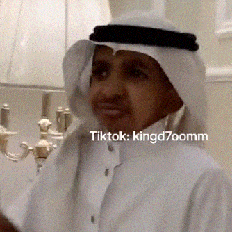 a man wearing a white shirt and a head scarf with tiktok kingd7oomm written on the bottom