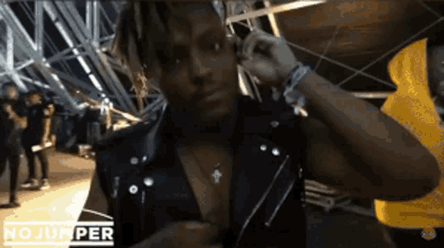 a man wearing a black leather vest is talking on a cell phone with the words no jumper on the bottom