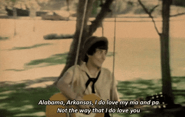 a person holding a guitar with the words alabama arkansas i do love my ma and pa