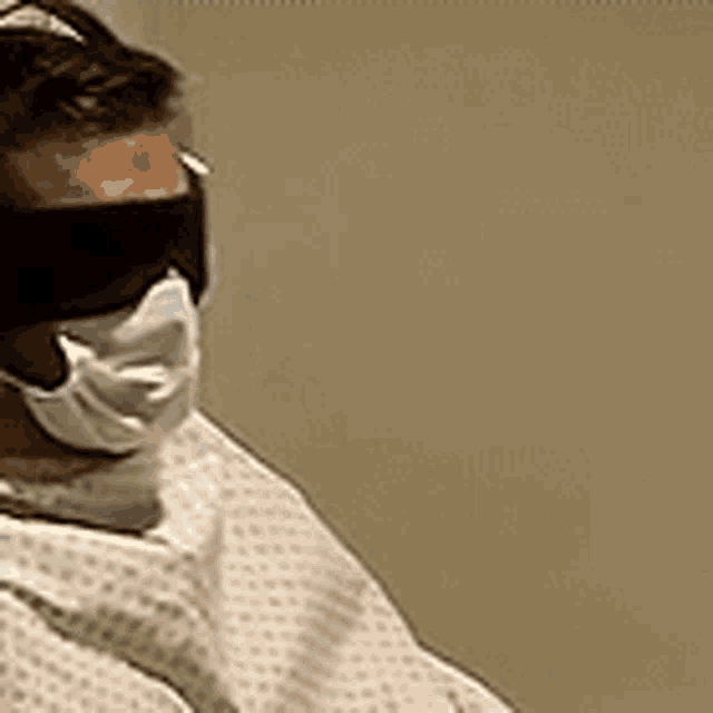 a man wearing a mask and blindfold is in a hospital room .