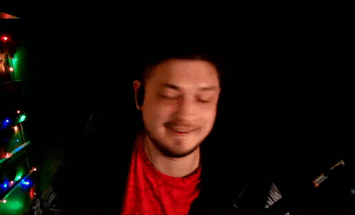 a man wearing headphones and a red shirt is giving a thumbs up sign .