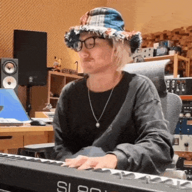 a man wearing a hat and glasses is playing a keyboard with the number 80 on it