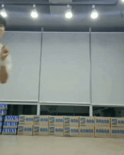 a man is standing in front of a row of boxes that say ' aa ' on them