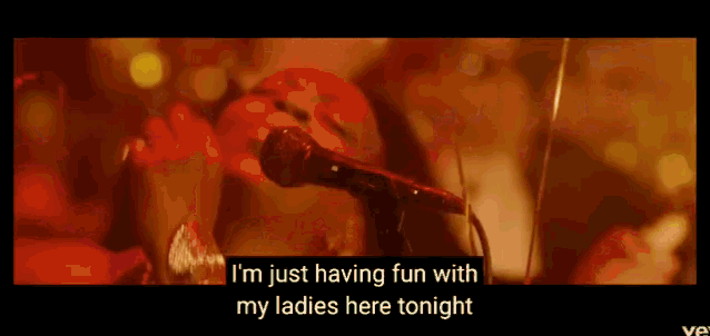 a woman singing into a microphone with the words " i 'm just having fun with my ladies here tonight "