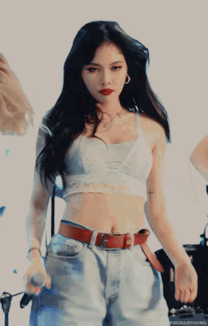a woman in a crop top is holding a microphone