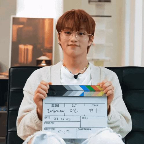 a young man is holding a clapper board that says interview