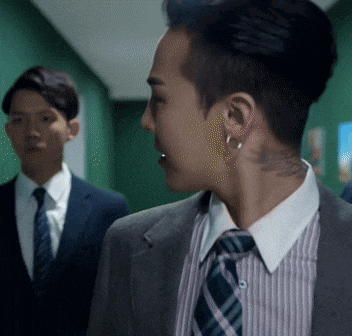 a man with a tattoo on his neck is wearing a suit