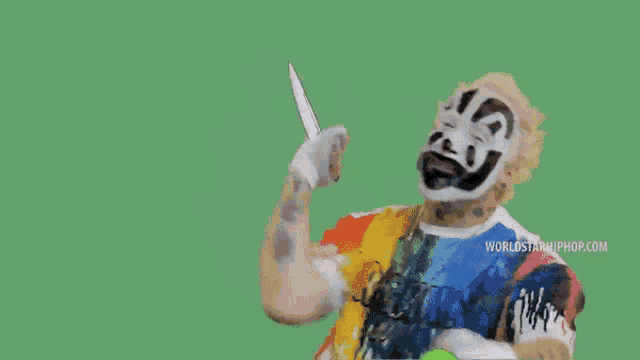 a man in a clown mask is holding a knife next to a green cartoon character .