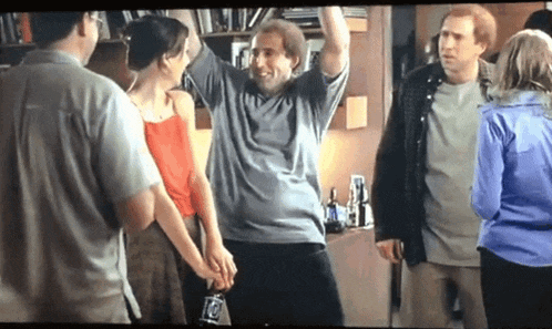 a group of people are standing around a man who is holding a bottle that says ' coca cola ' on it