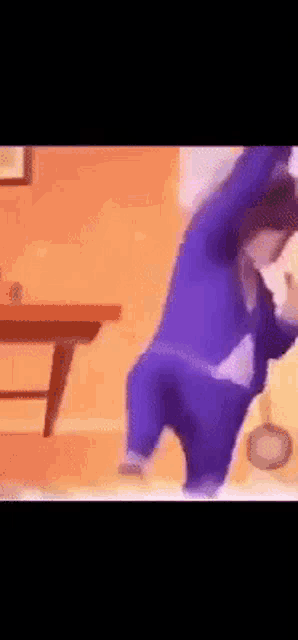 a person in purple pants is standing in front of a table