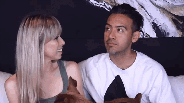 a man and a woman looking at each other with their dogs