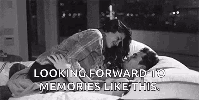 a black and white photo of a man and woman kissing on a bed with the words `` looking forward to memories like this '' .