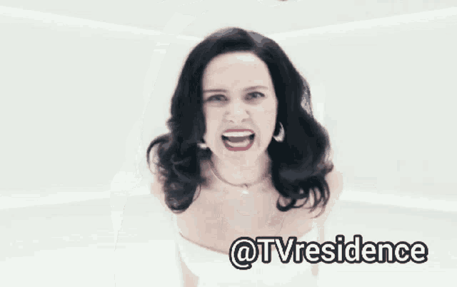 a woman in a white dress is making a funny face and the words @tvresidence are above her