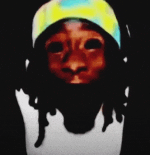 a close up of a person 's face with dreadlocks and a yellow hat