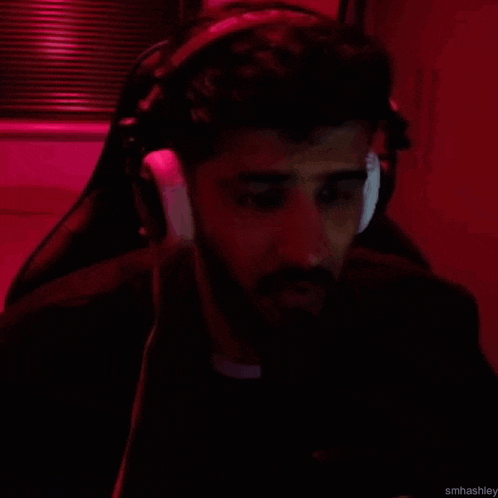 a man wearing headphones is sitting in a chair in a red room .