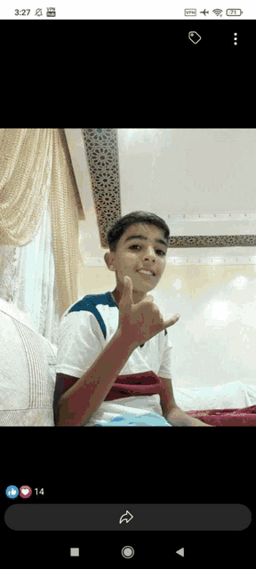 a young boy is giving a thumbs up in a photo taken on his phone