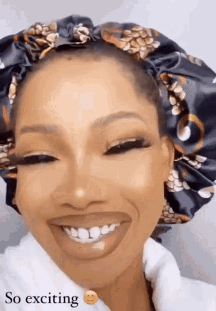 a woman wearing a satin bonnet is smiling with the words so exciting below her .