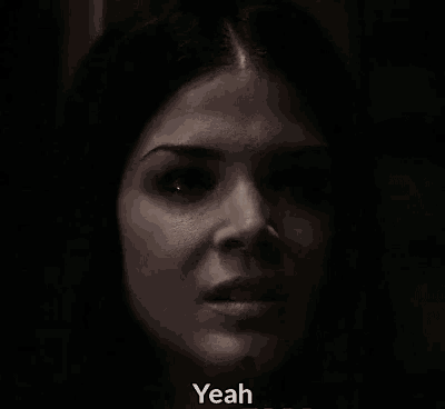 a close up of a woman 's face in the dark with the words `` yeah '' written below her .