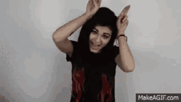 a woman in a black shirt with red highlights is making a funny face .
