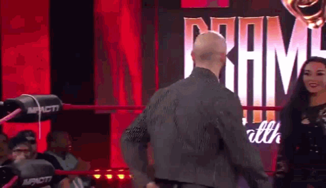 a man and a woman are in a wrestling ring .