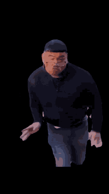 a man wearing glasses and a black shirt with his hands folded