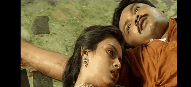 a man and a woman are laying next to each other on a bed .