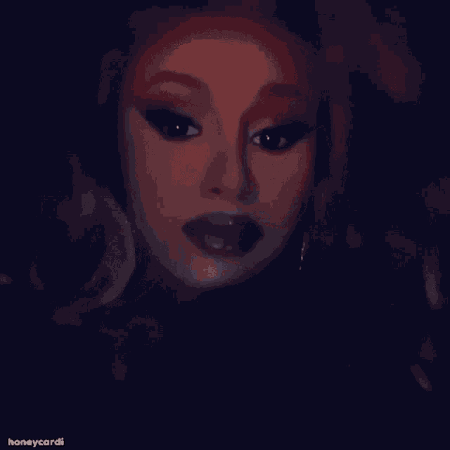 a close up of a woman 's face with a blurred background and the words honeycardi on the bottom