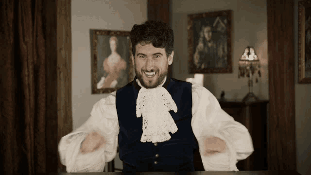 a man with a beard wearing a blue vest and white lace tie