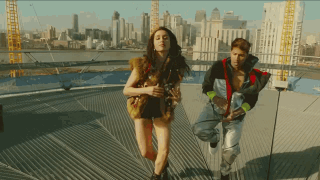 a man and a woman are running in front of a city