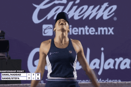 a woman stands in front of a caliente.mx sign