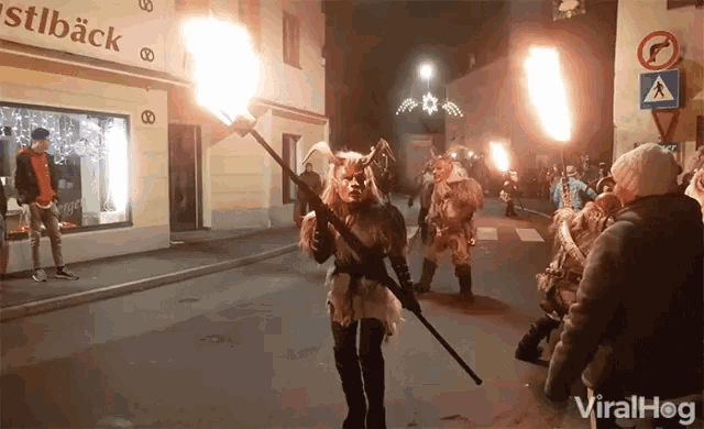 a man in a devil costume is holding a torch in front of a store called stlback