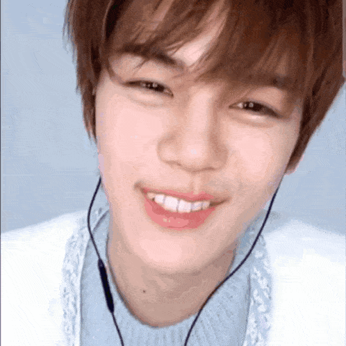 a close up of a young man wearing headphones and smiling