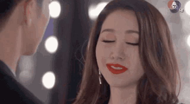 a woman with red lipstick is looking at a man .