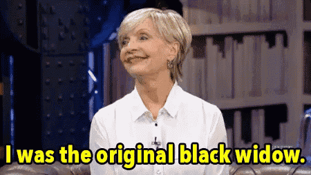 a woman is sitting on a couch with the words i was the original black widow .