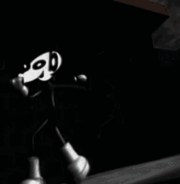 a black and white cartoon character with boxing gloves on is walking in a dark room .
