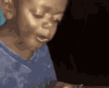 a girl in a blue shirt is making a funny face