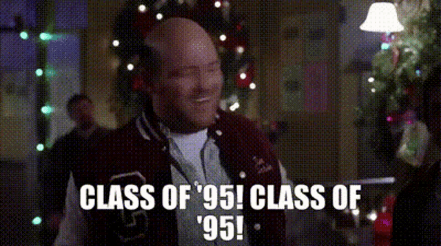 a man in a varsity jacket is standing in front of a christmas tree and says class of '95